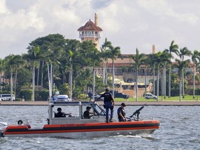 FILE - In this Nov. 22, 2018 photo, a U.S. Coast Guard patrol boat passes President Donald Trump's Mar-a-Lago estate in Palm Beach, Fla. A government watchdog says President Donald Trump's four trips to Mar-a-Lago in early 2017 cost taxpayers nearly $14 million.