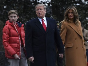 In this Feb. 1, 2019, photo, President Donald Trump, center, first lady Melania Trump, right, and their son Barron Trump, left, walk out of the White House and head to Marine One on the South Lawn of White House in Washington. A woman whose life sentence for drug offenses was commuted by President Donald Trump and a Delaware student allegedly bullied because his last name is Trump are among guests who will sit with first lady Melania Trump for the State of the Union address.