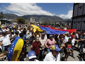 Opposition supporters converge in front of La Carlota military base urging soldiers to join their fight and allow the entry of U.S. humanitarian aid, in Caracas, Venezuela, Saturday, Feb. 23, 2019. Venezuela's military has served as the traditional arbiter of political disputes in the South American country, and in recent weeks, top leaders have pledged their unwavering loyalty to Maduro. However, many believe that lower-ranking troops who suffer from the same hardships as many other Venezuelans may be more inclined to now let the aid enter.