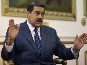 Venezuela's President Nicolas Maduro speaks during an interview with The Associated Press at Miraflores presidential palace in Caracas, Venezuela, Thursday, Feb. 14, 2019. Maduro is inviting a U.S. special envoy to come to Venezuela after revealing during the interview that his foreign minister recently held secret meetings with the U.S. official in New York.