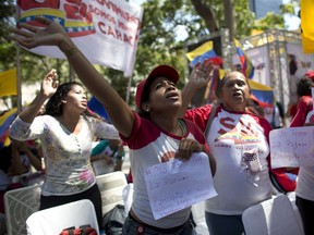 Supporters of President Nicolas Maduro sing a song about Venezuela's late president Hugo Chavez, during a event at Bolivar Square in Caracas, Venezuela, Thursday, Feb. 7, 2019.  Trucks carrying U.S. humanitarian aid destined for Venezuela arrived Thursday at the Colombian border, where opposition leaders vowed to bring them into their troubled nation despite objections from embattled President Nicolas Maduro.