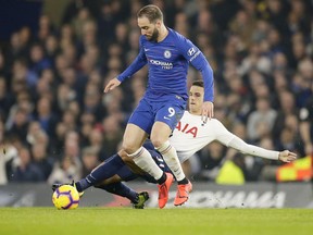 Chelsea's Gonzalo Higuain, left, is tackled by Tottenham's Erik Lamela during the English Premier League soccer match between Chelsea and Tottenham Hotspur at Stamford Bridge stadium, in London, dow}, Feb. 27, 2019.