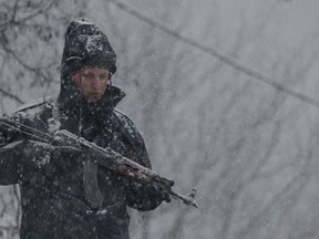 Bosnian police secure an area in Bradina, Bosnia, Monday, Feb. 11, 2019. Police in Bosnia say they have launched a manhunt for a suspect in the killings of two people in the past week which has triggered panic in the country.