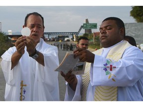 Venezuelans and Brazilians attend a Mass conducted by Venezuelan priests, next to a border checkpoint in Pacaraima, Roraima state, Brazil, Friday, Feb.22, 2019. Heightened tensions in Venezuela left a woman dead and a dozen injured near the border with Brazil on Friday, in the first deadly clash over the opposition's attempts to bring in emergency food and medicine that President Nicolas Maduro says isn't needed and has vowed to block.