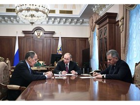 Russian President Vladimir Putin center, attends a meeting with Russian Foreign Minister Sergey Lavrov, left, and Defense Minister Sergei Shoigu in the Kremlin in Moscow, Russia, Saturday, Feb. 2, 2019.