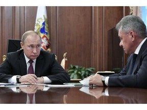 Russian President Vladimir Putin, left, speaks to Defense Minister Sergei Shoigu during a meeting in the Kremlin in Moscow, Russia, Saturday, Feb. 2, 2019. Putin said that Russia will abandon the 1987 Intermediate-Range Nuclear Forces treaty, following in the footsteps of the United States, but noted that Moscow will only deploy intermediate-range nuclear missiles if Washington does so.