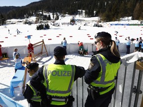 Austrian Federal Police officers stand at the finish area of a men's cross country skiing 15km classic competition, at the Nordic Ski World Championships, in Seefeld, Austria, Wednesday, Feb. 27, 2019. Austrian authorities say five elite athletes and four others have been arrested in doping raids in the country and neighboring Germany amid the Nordic skiing world championships.