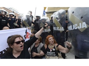 FILE - In this May 1, 2018, file photo, anti-fascists shout slogans against members of the far-right National-Radical Camp in Warsaw, Poland. Poland's political fissures have widened in recent months, pitting conservatives, many of them government supporters, against liberal critics who accuse the leadership of threatening the country's hard-won democracy by undermining the independence of the judiciary and the media.