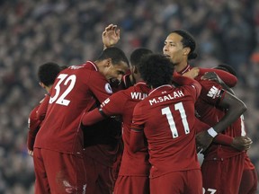 Liverpool's Divock Origi celebrates with teammates after scoring his side's third goal during the English Premier League soccer match between Liverpool and Watford at Anfield stadium in Liverpool, England, Wednesday, Feb. 27, 2019.