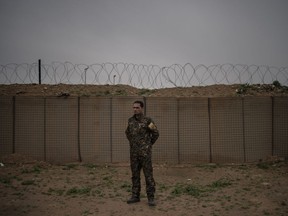 U.S.-backed Syrian Democratic Forces (SDF) commander Adnan Afrin, poses for a photo in the in Omar oil field base, Syria, Friday, Feb. 15, 2019. Adnan Afrin told The Associated Press that in the last three days, the Islamic State group has brought up from underground tunnels hundreds of civilians, to let them be known to the SDF and the U.S.-led coalition. He says the discovery has blunted the offensive. "We do not want to cause a massacre."