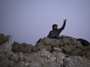 A U.S.-backed Syrian Democratic Forces (SDF) fighter reacts as an airstrike hits territory still held by Islamic State militants in the desert outside Baghouz, Syria, Tuesday, Feb. 19, 2019. The Islamic State group has been reduced from its self-proclaimed caliphate that once spread across much of Syria and Iraq at its height in 2014 to a speck of land on the countries' shared border.