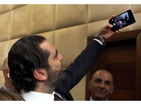 Newly-assigned Lebanese Prime Minister Saad Hariri, takes a selfie with reporters after he announced his new cabinet, at the presidential palace in Baabda, east of Beirut, Lebanon, Thursday, Jan. 31, 2019. Lebanese political factions have agreed on the formation of a new government, breaking a nine-month deadlock that only deepened the country' economic woes.