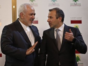 Lebanese Foreign Minister Gebran Bassil, right, speaks with his Iranian counterpart Mohammad Javad Zarif, in Beirut, Lebanon, Monday, Feb. 11, 2019. Zarif extended an offer for Iranian military assistance to the U.S.-backed Lebanese army on Sunday, saying Iran is ready to assist in all sectors should the Lebanese government want it.