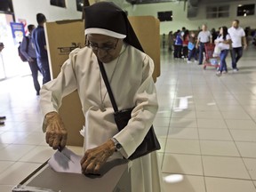 Nun Zoila Hernandez casts her vote during the presidential election at a polling station in San Salvador, El Salvador, Sunday, Feb. 3, 2019. Salvadorans are choosing from among a handful of presidential candidates all promising to end corruption, stamp out gang violence and create more jobs in the Central American nation.