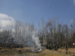 ADDS HELICOPTER CRASH AND UPDATES CASUALTIES - Kashmiri villagers and Indian soldiers gather near the wreckage of an Indian helicopter after it crashed in Budgam area, outskirts of Srinagar, Indian controlled Kashmir, Wednesday, Feb.27, 2019. The crash killed six Indian air force officials and a civilian on the ground.