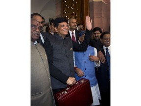 Interim Finance Minister Piyush Goyal, center, holds a briefcase containing federal budget documents and waves to media upon his arrival at the parliament house in New Delhi, India, Friday, Feb. 1, 2019. The Bharatiya Janata Party-led National Democratic Alliance government will present its last budget of five-year tenure on Feb. 1 as it prepares to face tens of millions of voters in national elections to be held by May.