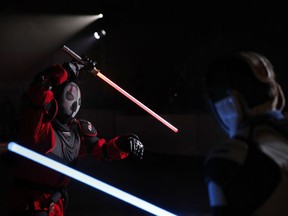 In this Sunday, Feb. 10, 2019, photo, Julien Esprit, left, competes with Jean Baptiste Marchetti-Waternaux during a national lightsaber tournament in Beaumont-sur-Oise, north of Paris. In France, it is easier than ever now to act out "Star Wars" fantasies. The fencing federation has officially recognized lightsaber dueling as a competitive sport.