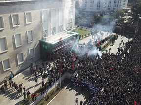 Opposition supporters take part in an anti-government rally in capital Tirana, Albania, Saturday, Feb. 16, 2019. Thousands of Albanian opposition supporters have clashed with police in an anti-government rally to protest what they says is a corrupt and inefficient Cabinet, asking for its resignation and early elections.