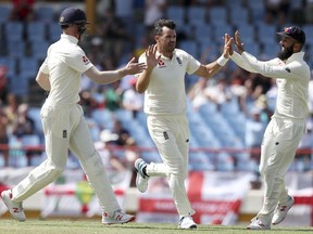 England's James Anderson celebrates taking the wicket of West Indies' captain Kraigg Brathwaite with teammates Moeen Ali, right, and Keaton Jennings during day four of the third cricket Test match at the Daren Sammy Cricket Ground in Gros Islet, St. Lucia, Tuesday, Feb. 12, 2019.