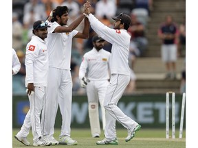 Sri Lanka's Kasun Rajitha, second left, celebrates with teammates after bowling out Australia's Joe Burns for 180 runs on day 2 of their cricket test match in Canberra, Saturday, Feb. 2, 2019.