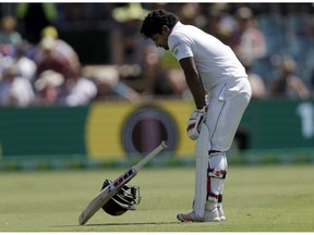 Sri Lanka's Kusal Perera bends over as he begins to walk off the ground after he was struck on the head by a delivery from Australia's Jhye Richardson on day 3 of their cricket test match in Canberra, Sunday, Feb. 3, 2019.