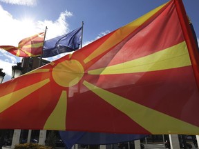 Macedonian and NATO flag wave in front of the government building during a ceremony in Skopje, Tuesday, Feb. 12, 2019. Macedonian authorities began removing official signs from government buildings to prepare for the country's new name: North Macedonia.