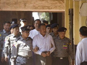 Kyi Lin, center, the gunman who shot a prominent Muslim lawyer who was a close adviser of Myanmar leader Aung San Suu Kyi, is escorted by police at Yangon Northern District Court in Yangon, Myanmar, Friday, Feb. 15, 2019. The court found Kyi Lin guilty of premeditated murder and illegal weapons possession and sentenced to death for the Jan. 29, 2017 shooting of lawyer Ko Ni in broad daylight at Yangon airport.