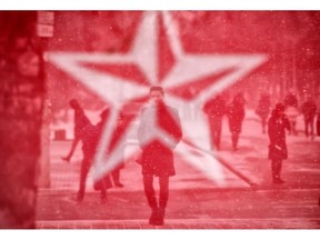 Seen through the mesh covering an electoral advertising point of the Socialits' Party, people walk in Chisinau, Moldova, Saturday, Feb. 23, 2019, a day before the country holds parliamentary elections. Moldova's President Igor Dodon expressed, in an interview with the Associated Press, concern of "massive protests" in case of suspicions of fraud in the upcoming parliamentary elections.