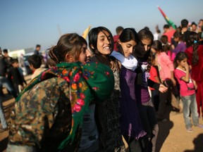Yazidi refugees celebrate news of the liberation of her homeland of Sinjar from ISIL extremists, while at a refugee camp on November 13, 2015 in Derek, Rojava, Syria.