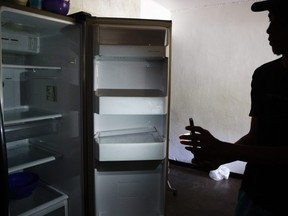A man shows his empty fridge with the help of a cell phone flashlight during blackouts which affect the water pumps on March 12, 2019 in Caracas, Venezuela.