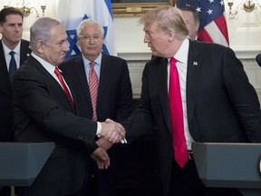Prime Minister of Israel Benjamin Netanyahu (Front L) and US President Donald J. Trump (Front R) shake hands before Trump signed an order recognizing Golan Heights as Israeli territory, in the Diplomatic Reception Room of the White House March 25, in Washington, DC.