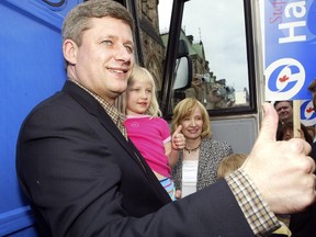 Conservative leader Stephen Harper gives the thumbs up with his daughter Rachel and his wife Laureen Harper on outside the campaign bus on Parliament Hill on May 23, 2004.