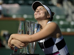 Bianca Andreescu, of Canada, smiles as she hugs her trophy after defeating Angelique Kerber, of Germany, in the women's final at the BNP Paribas Open tennis tournament Sunday, March 17, 2019, in Indian Wells, Calif.