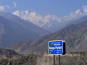 In this photograph taken on August 7, 2014 a sign points towards a view of Nanga Parbat, the killer mountain on Karakoram Highway in Pakistan's nothern area of Gilgit.