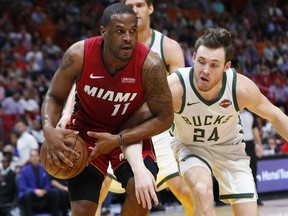 Miami Heat guard Dion Waiters (11) and Milwaukee Bucks guard Pat Connaughton (24) compete for a loose ball during the first half of an NBA basketball game Friday, March 15, 2019, in Miami.