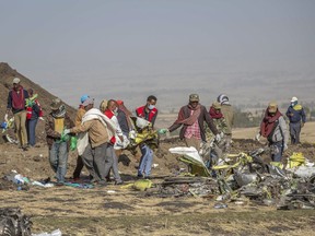 Rescuers work at the scene of an Ethiopian Airlines flight crash near Bishoftu, or Debre Zeit, south of Addis Ababa,  Ethiopia, Monday, March 11, 2019. A spokesman says Ethiopian Airlines has grounded all its Boeing 737 Max 8 aircraft as a safety precaution, following the crash of one of its planes in which 157 people were killed.