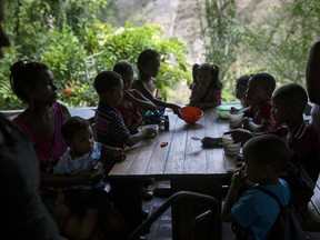 In this Feb. 14, 2019 photo, children eat in a soup kitchen where they scoop spoonfuls of rice and scrambled eggs in what could be their only meal of the day, in the Petare slum, in Caracas, Venezuela. Part of the tragedy of daily life in socialist Venezuela can be glimpsed in this small volunteer soup kitchen in the heart of one of Latin America's biggest slums, which helps dozens of children as well as unemployed mothers who can no longer feed them.