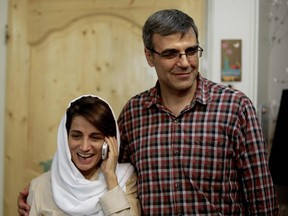 In this file photo taken on September 18, 2013 Iranian lawyer Nasrin Sotoudeh (L) speaks on the phone next to her husband Reza Khandan as they pose for a photo at their house in Tehran.