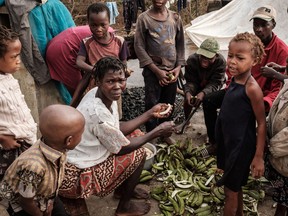 People peel bananas on a rooftop in Buzi, Mozambique.