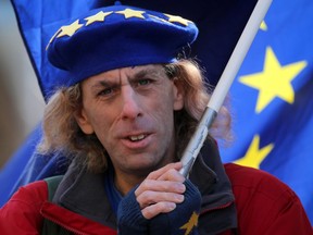 An anti-Brexit protester wearing a European flag beret waits outside the Houses of Parliament in London on March 25, 2019.