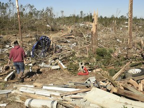 Residents searching for belongings are dwarfed by the devastation in Beauregard, Ala., Wednesday, March 6, 2019. The twister that smashed Beauregard was the deadliest U.S. tornado in nearly six years. The weather service said it remained on the ground for an hour and 16 minutes, crossing the Chattahoochee River into western Georgia along a path stretching roughly 70 miles