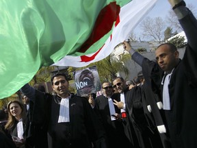 Algerian lawyers demonstrate with a national flag outside the constitutional council in a protest against President Abdelaziz Bouteflika, Thursday March 7, 2019 in Algiers. The Algerian leader, in power since 1999 and all but invisible since a stroke in 2013, is running for a fifth term.