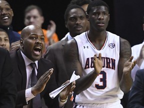 In this Jan. 19, 2019 photo, Auburn assistant coach Ira Bowman, left, cheers from the sidelines during the second half of an NCAA college basketball game against Kentucky in Auburn, Ala. Auburn has suspended Bowman indefinitely on Wednesday, March 3, 2019, amid allegations that he was involved in a bribery scheme during his time at the University of Pennsylvania.