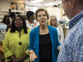 Democratic presidential candidate Sen. Elizabeth Warren, D-Mass., center, talks with owner Tim Williamson at Cater's Drug Store in Selma, Ala., on Tuesday, March 19, 2019.