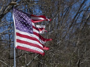 A tattered American flag waves in the wind near the most damaged area in Beauregard, Ala., on Tuesday March 5, 2019. A fatal tornado struck Beauregard on Sunday afternoon.