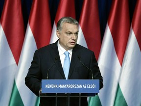 FILE  - In this Sunday, Feb. 10, 2019 file photo, Hungarian Prime Minister Viktor Orban delivers his annual "State of Hungary" speech in Budapest, Hungary.  The inscription reads: "For us Hungary is the first!" Hungary's populist prime minister says calls for his party's expulsion from a European Parliament group serve left-wing rivals. The debate in the European People's Party follows a Hungarian government ad campaign against migration.
