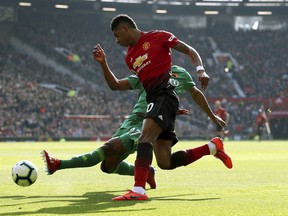 Watford's Christian Kabasele, background and Manchester United's Marcus Rashford battle for the ball, during the English Premier League soccer match between Manchester United and Watford, at Old Trafford, in Manchester, England, Saturday March 30, 2019.