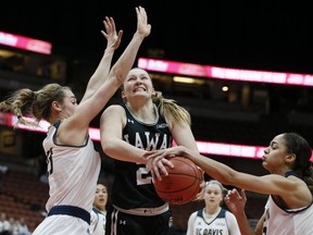 Hawaii forward Amy Atwell, center, works between UC Davis forwards Kayla Konrad, left, and Cierra Hall, right, for the ball during the first half of an NCAA college basketball game for the Big West women's tournament championship in Anaheim, Calif., Saturday, March 16, 2019.