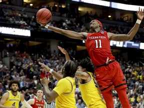 Texas Tech forward Tariq Owens (11) shoots over Michigan defenders during the second half an NCAA men's college basketball tournament West Region semifinal Thursday, March 28, 2019, in Anaheim, Calif.