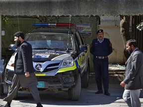 Worshipers walk past a police vehicle stationed outside a mosque belonging to a banned religious group in Islamabad, Pakistan, Wednesday, March 6, 2019. Pakistan on Wednesday continued a crackdown on seminaries, mosques and hospitals belonging to outlawed groups, saying the actions were part of the government efforts aimed at fighting terrorism, extremism and militancy.